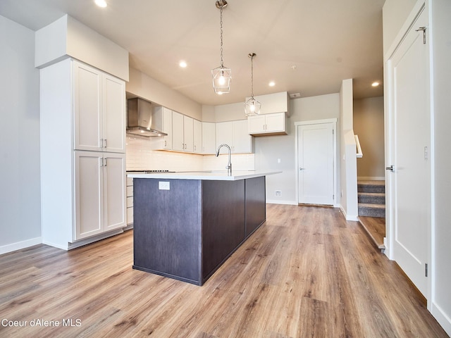1048 E 4th Ave, Post Falls, ID 83854 - kitchen featuring wall chimney exhaust hood, recessed lighting, white cabinets, and light wood-style flooring