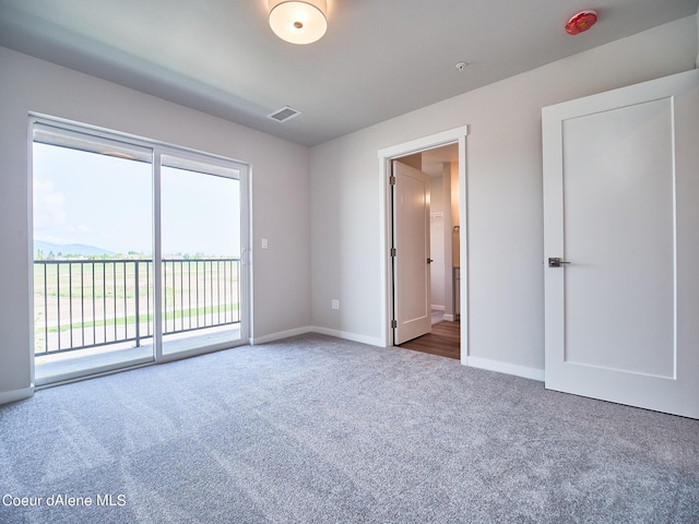 1048 E 4th Ave, Post Falls, ID 83854 - unfurnished bedroom with access to exterior, carpet flooring, multiple windows, and baseboards