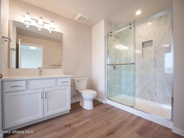 1048 E 4th Ave, Post Falls, ID 83854 - bathroom featuring toilet, a shower stall, vanity, wood finished floors, and baseboards