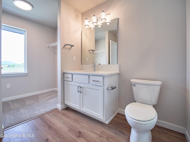 1048 E 4th Ave, Post Falls, ID 83854 - bathroom featuring vanity, wood finished floors, toilet, and baseboards