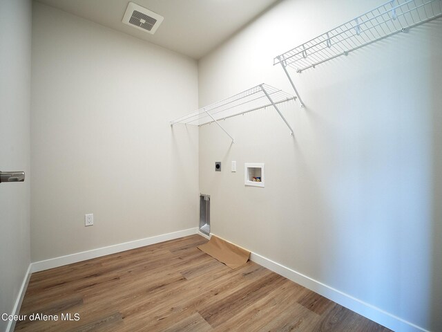 1048 E 4th Ave, Post Falls, ID 83854 - laundry area with hookup for an electric dryer, wood finished floors, hookup for a washing machine, and baseboards