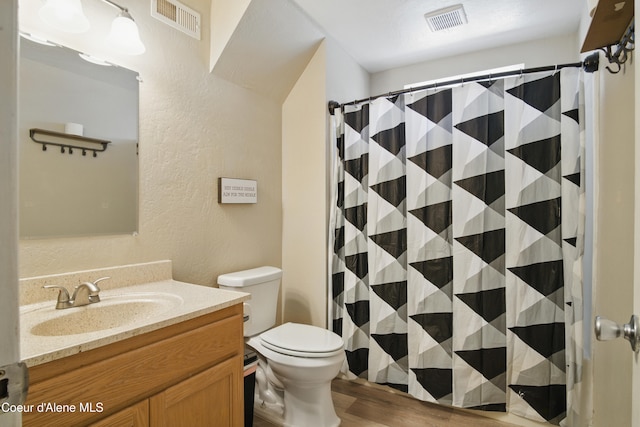 15272 N Stevens St, Rathdrum, ID 83858 - bathroom with a textured wall, vanity, wood finished floors, toilet, and curtained shower