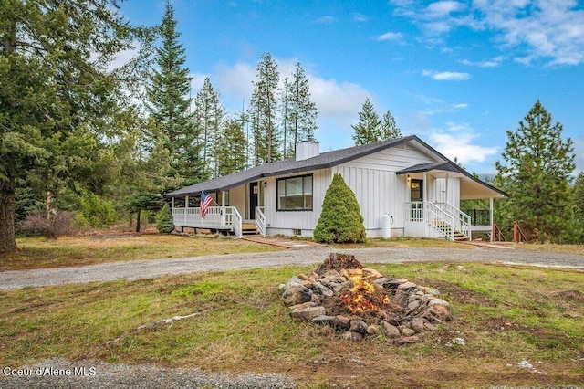 16 Beers Humbird Rd, Sagle, ID 83860 - view of front of property with a porch, a chimney, a fire pit, and a front lawn