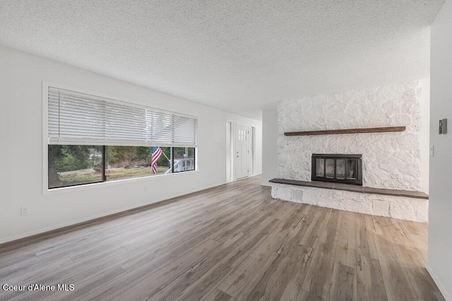 16 Beers Humbird Rd, Sagle, ID 83860 - unfurnished living room with wood finished floors, a textured ceiling, and a fireplace