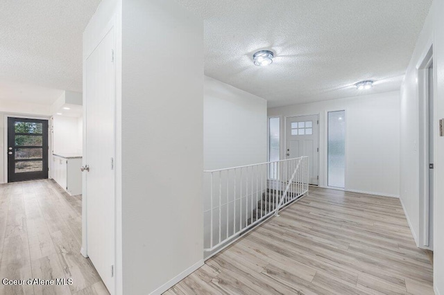 16 Beers Humbird Rd, Sagle, ID 83860 - corridor with a textured ceiling, light wood finished floors, and an upstairs landing