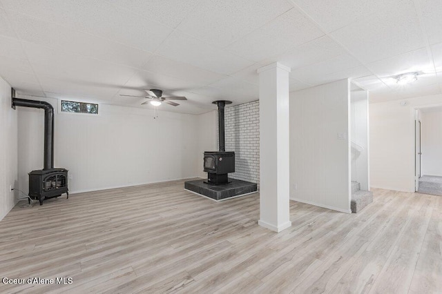 16 Beers Humbird Rd, Sagle, ID 83860 - unfurnished living room featuring a wood stove, wood finished floors, a drop ceiling, and a ceiling fan