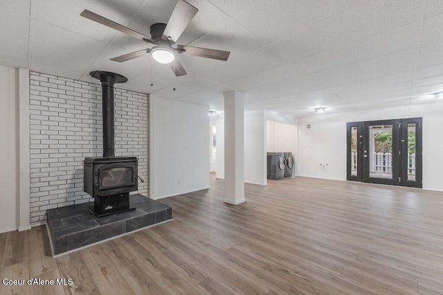 16 Beers Humbird Rd, Sagle, ID 83860 - unfurnished living room featuring washing machine and dryer, a wood stove, wood finished floors, and a ceiling fan