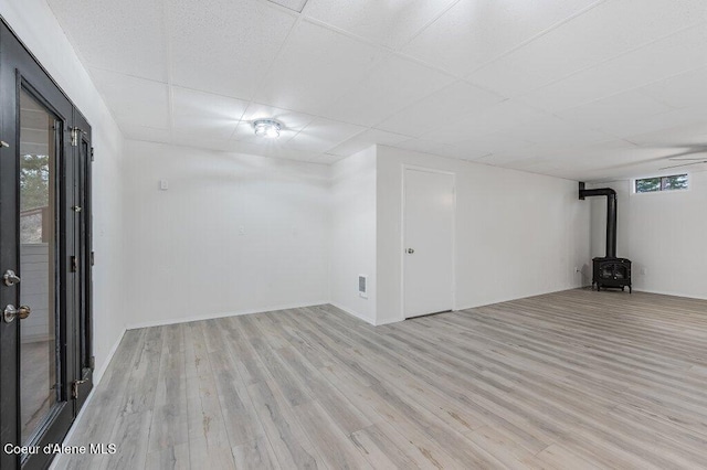 16 Beers Humbird Rd, Sagle, ID 83860 - basement featuring a wood stove, wood finished floors, and a paneled ceiling