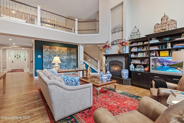 2177 E Totten Ln, Dalton Gardens, ID 83815 - living room featuring wood finished floors, high vaulted ceiling, a lit fireplace, and stairs