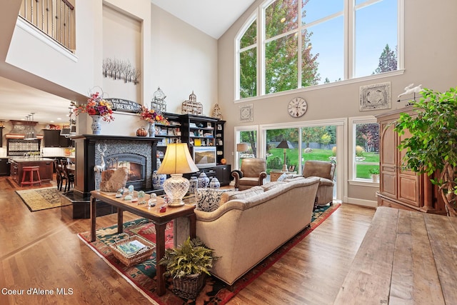 2177 E Totten Ln, Dalton Gardens, ID 83815 - living area with high vaulted ceiling, a warm lit fireplace, light wood-type flooring, and healthy amount of natural light