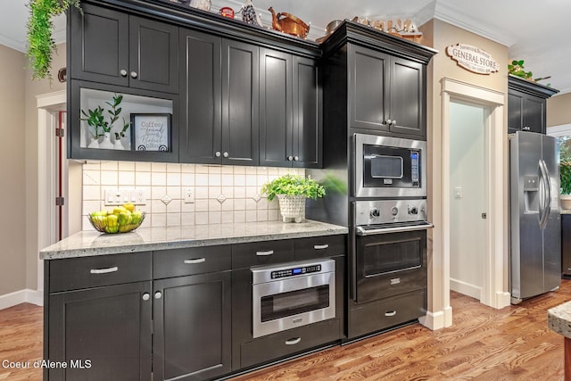 2177 E Totten Ln, Dalton Gardens, ID 83815 - kitchen featuring stainless steel appliances, light wood finished floors, tasteful backsplash, ornamental molding, and baseboards