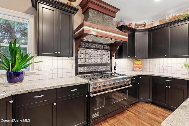 2177 E Totten Ln, Dalton Gardens, ID 83815 - kitchen featuring range with two ovens, light wood-style flooring, light stone counters, backsplash, and custom exhaust hood