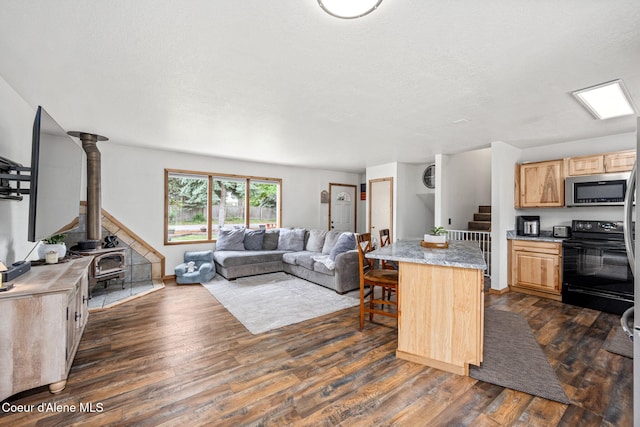 8525 W Nevada St, Rathdrum, ID 83858 - kitchen with black electric range, stainless steel microwave, light brown cabinetry, open floor plan, and dark wood-type flooring
