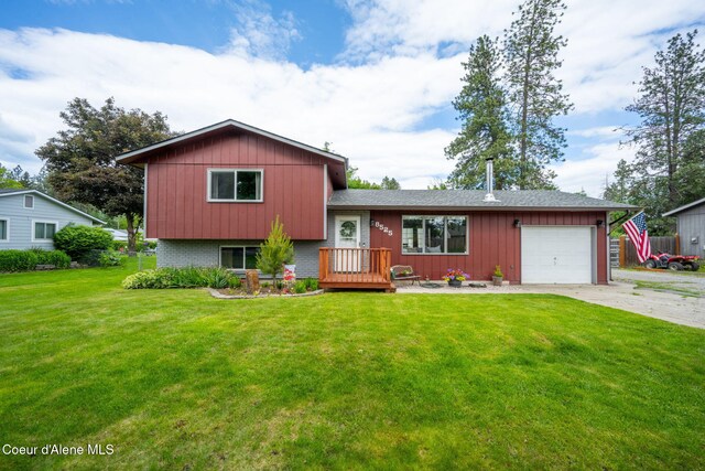8525 W Nevada St, Rathdrum, ID 83858 - tri-level home with a garage, driveway, and a front lawn