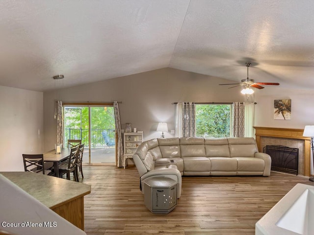 5735 E Steamboat Bnd, Post Falls, ID 83854 - living area with vaulted ceiling, wood finished floors, ceiling fan, a textured ceiling, and a fireplace