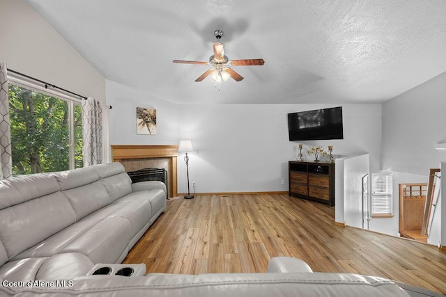 5735 E Steamboat Bnd, Post Falls, ID 83854 - living room with wood-type flooring, ceiling fan, baseboards, and a tile fireplace