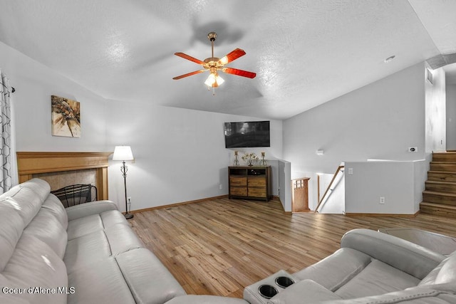5735 E Steamboat Bnd, Post Falls, ID 83854 - living room with vaulted ceiling, wood finished floors, ceiling fan, a textured ceiling, and baseboards