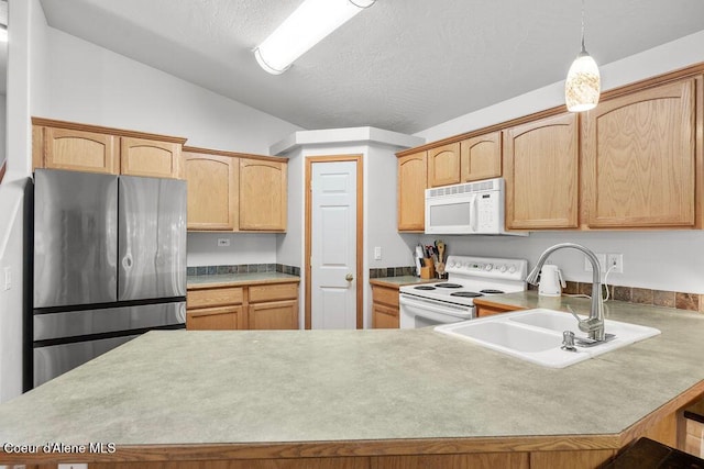 5735 E Steamboat Bnd, Post Falls, ID 83854 - kitchen with white appliances, a sink, a peninsula, light countertops, and a textured ceiling