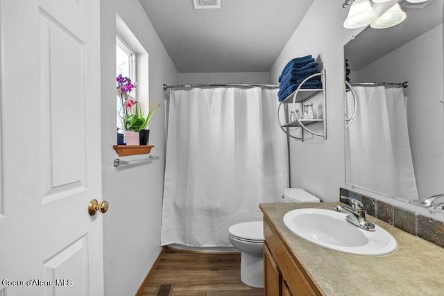 5735 E Steamboat Bnd, Post Falls, ID 83854 - bathroom with toilet, vanity, wood finished floors, and curtained shower