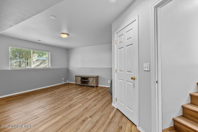 5735 E Steamboat Bnd, Post Falls, ID 83854 - unfurnished living room featuring light wood finished floors, stairway, and baseboards
