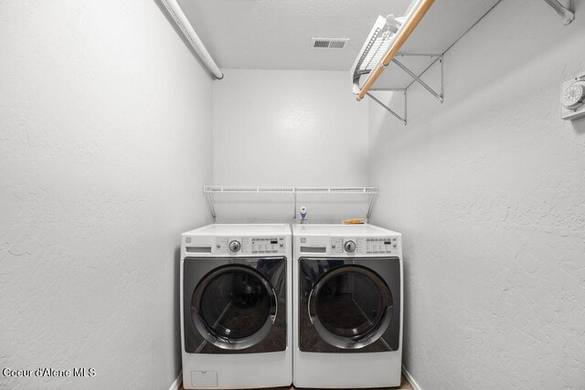 5735 E Steamboat Bnd, Post Falls, ID 83854 - laundry area with separate washer and dryer, baseboards, and a textured wall
