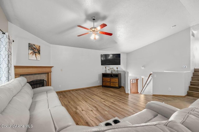 5735 E Steamboat Bnd, Post Falls, ID 83854 - living room featuring ceiling fan, light wood-style flooring, lofted ceiling, baseboards, and a fireplace