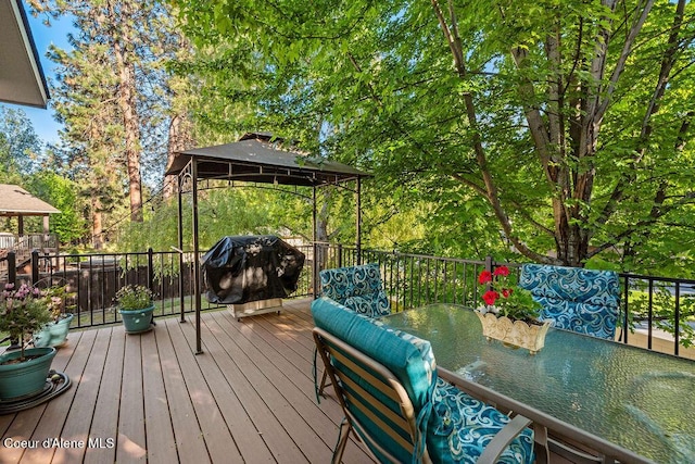 5735 E Steamboat Bnd, Post Falls, ID 83854 - wooden terrace with a gazebo, outdoor dining area, grilling area, and view of scattered trees
