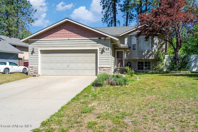7349 W Crenshaw St, Rathdrum, ID 83858 - tri-level home featuring an attached garage, stone siding, driveway, and a front yard