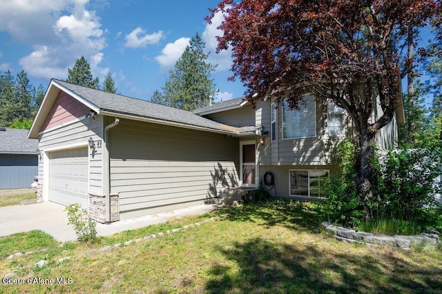 7349 W Crenshaw St, Rathdrum, ID 83858 - tri-level home featuring a front lawn, an attached garage, driveway, and roof with shingles