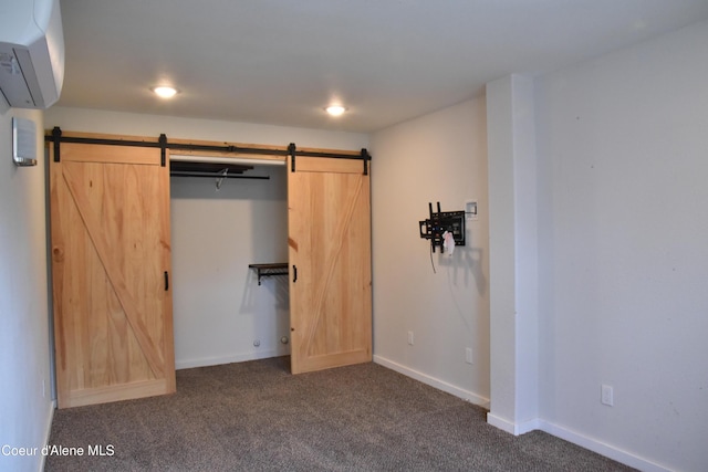 574 Parkside Rd, Plummer, ID 83851 - unfurnished bedroom featuring a barn door, dark carpet, an AC wall unit, and baseboards