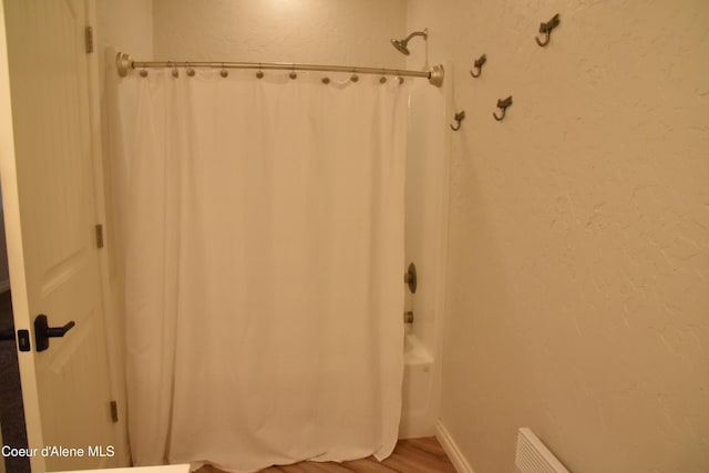 574 Parkside Rd, Plummer, ID 83851 - full bathroom featuring wood finished floors, shower / bath combo with shower curtain, and a textured wall