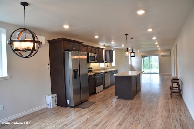 574 Parkside Rd, Plummer, ID 83851 - kitchen with appliances with stainless steel finishes, a chandelier, dark brown cabinets, light wood-type flooring, and a kitchen island