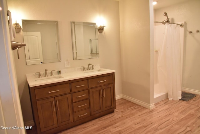 574 Parkside Rd, Plummer, ID 83851 - bathroom featuring wood finished floors, double vanity, baseboards, and a shower with shower curtain