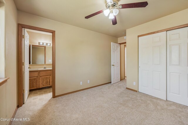 321 E Acorn Ave, Coeur Dalene, ID 83814 - unfurnished bedroom featuring light carpet, a closet, connected bathroom, and baseboards