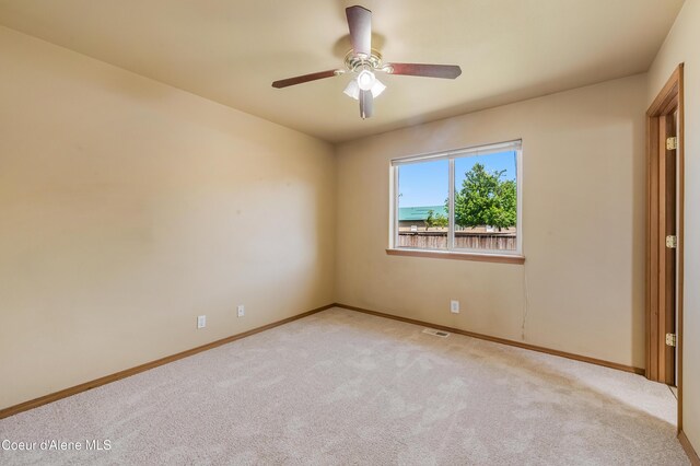321 E Acorn Ave, Coeur Dalene, ID 83814 - unfurnished room with light colored carpet, a ceiling fan, and baseboards