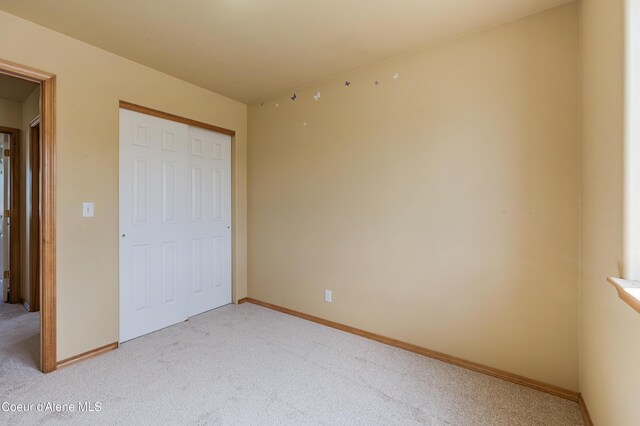 321 E Acorn Ave, Coeur Dalene, ID 83814 - unfurnished bedroom featuring light colored carpet, a closet, and baseboards
