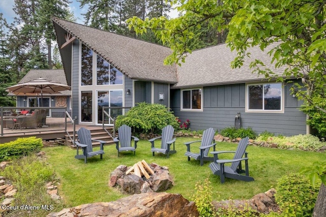 4987 S Bay Pointe Way, Coeur Dalene, ID 83814 - back of house with an outdoor fire pit, a wooden deck, a lawn, a shingled roof, and board and batten siding
