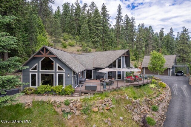 4987 S Bay Pointe Way, Coeur Dalene, ID 83814 - rear view of property with a wooden deck, an outdoor structure, and a shingled roof