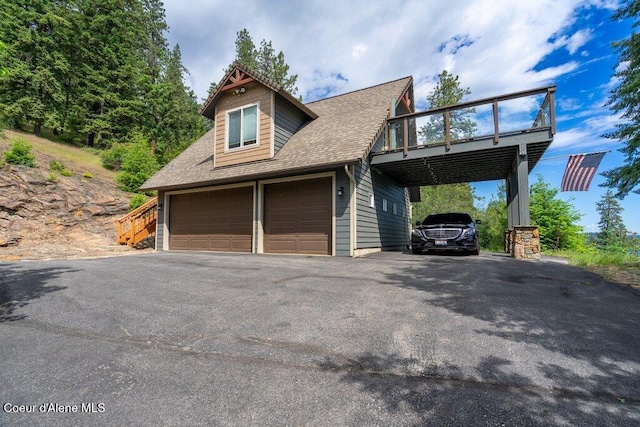4987 S Bay Pointe Way, Coeur Dalene, ID 83814 - view of front of property featuring a carport, a shingled roof, asphalt driveway, a garage, and a wooden deck