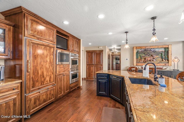 4987 S Bay Pointe Way, Coeur Dalene, ID 83814 - kitchen featuring a sink, appliances with stainless steel finishes, light stone countertops, dark wood-style flooring, and decorative light fixtures