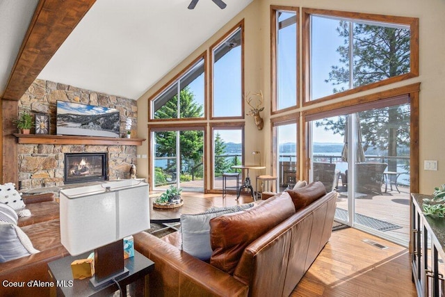4987 S Bay Pointe Way, Coeur Dalene, ID 83814 - living room with high vaulted ceiling, wood finished floors, a stone fireplace, and a ceiling fan