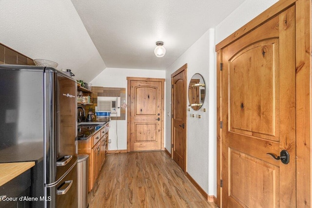4987 S Bay Pointe Way, Coeur Dalene, ID 83814 - kitchen with freestanding refrigerator, light wood-type flooring, a sink, brown cabinetry, and dark countertops