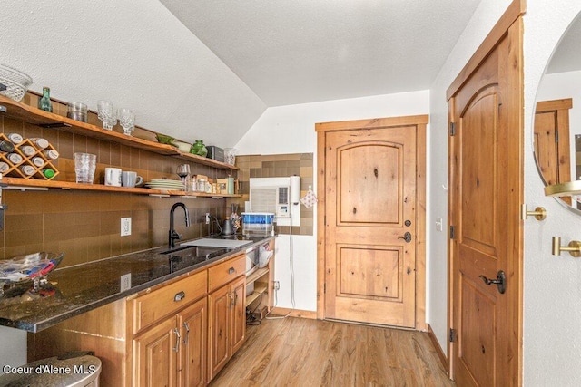 4987 S Bay Pointe Way, Coeur Dalene, ID 83814 - bar area featuring a sink, light wood-style flooring, arched walkways, vaulted ceiling, and tasteful backsplash
