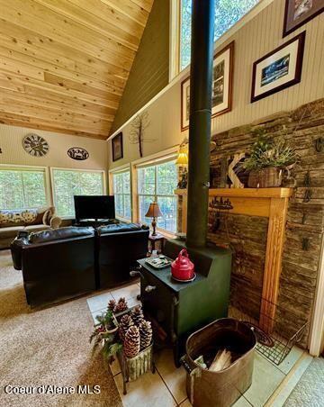 22767 Spruce Ln, Lewiston, ID 83501 - living area featuring high vaulted ceiling, a wood stove, plenty of natural light, and wood ceiling