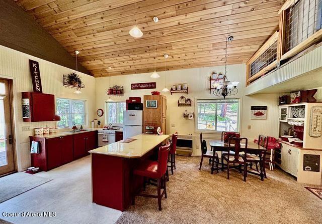 22767 Spruce Ln, Lewiston, ID 83501 - kitchen featuring freestanding refrigerator, wood ceiling, a sink, a center island, and a chandelier
