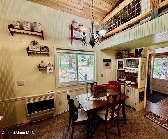22767 Spruce Ln, Lewiston, ID 83501 - dining area featuring heating unit, a chandelier, wood ceiling, carpet, and high vaulted ceiling