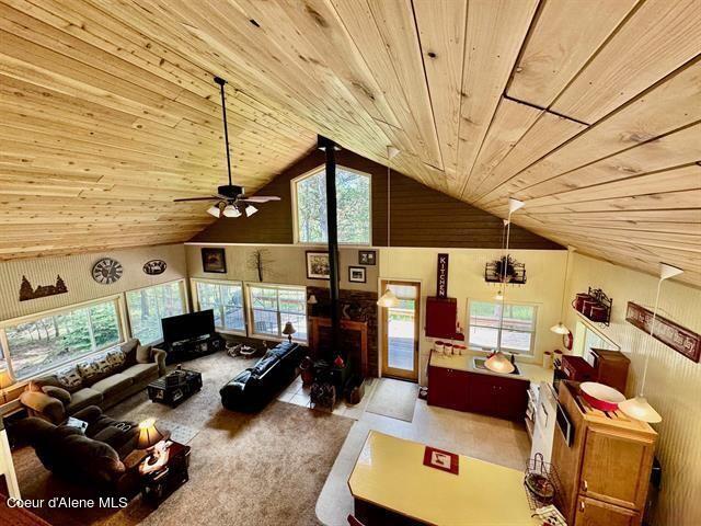 22767 Spruce Ln, Lewiston, ID 83501 - living area featuring wooden ceiling, high vaulted ceiling, a ceiling fan, and a wood stove