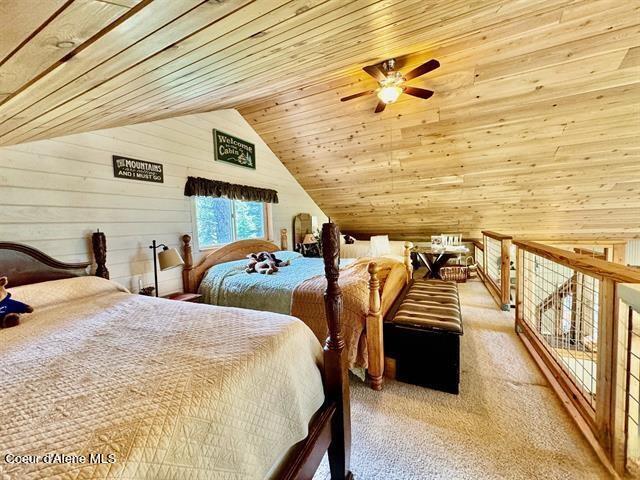 22767 Spruce Ln, Lewiston, ID 83501 - bedroom featuring carpet floors, wooden walls, wood ceiling, and vaulted ceiling