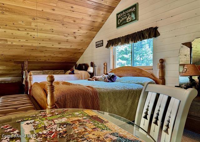 22767 Spruce Ln, Lewiston, ID 83501 - bedroom featuring lofted ceiling, wooden walls, and wood ceiling