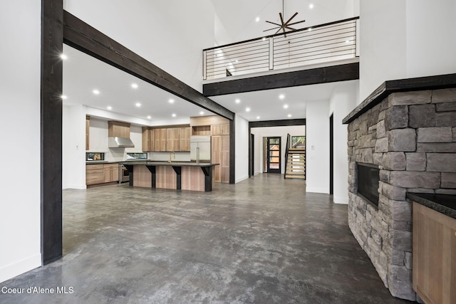 541 N Idaho Club Dr, Sandpoint, ID 83864 - unfurnished living room featuring a high ceiling, finished concrete flooring, baseboards, a fireplace, and recessed lighting